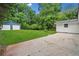 Large backyard features a spacious lawn, concrete patio, and a two-car detached garage at 414 Landers Sw Dr, Mableton, GA 30126