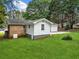 Charming brick and white-paneled home with a lush green lawn and mature trees at 414 Landers Sw Dr, Mableton, GA 30126