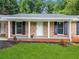 Welcoming front porch with brick columns, black shutters, and a freshly painted white front door at 414 Landers Sw Dr, Mableton, GA 30126
