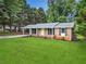 Brick home with a neatly maintained lawn, a cozy covered porch, and an attached carport at 414 Landers Sw Dr, Mableton, GA 30126