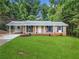 Charming brick home featuring a well-manicured front lawn, a covered porch, and a convenient carport at 414 Landers Sw Dr, Mableton, GA 30126