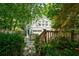 Landscaped backyard with stone walkway, lush greenery, and a charming white house in the background at 630 Cleburne Ne Ter, Atlanta, GA 30306