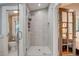 Bright bathroom featuring a walk-in shower, glass door, tiled walls, and a view into another room at 630 Cleburne Ne Ter, Atlanta, GA 30306