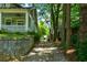Long driveway beside a home with a porch, leading to a backyard with trees and a stone retaining wall at 630 Cleburne Ne Ter, Atlanta, GA 30306