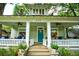 Charming porch with ceiling fans, white columns, and a bright teal front door at 630 Cleburne Ne Ter, Atlanta, GA 30306