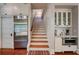 Hallway with wooden staircase, stainless steel refrigerator, and custom cabinets at 630 Cleburne Ne Ter, Atlanta, GA 30306