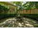 Charming stone patio with outdoor seating, surrounded by manicured bushes and mature trees at 630 Cleburne Ne Ter, Atlanta, GA 30306