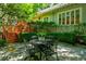 Outdoor patio with metal table and chairs, surrounded by lush greenery and a view of the home at 630 Cleburne Ne Ter, Atlanta, GA 30306