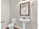 Half-bath with a pedestal sink, decorative mirror, and neutral wall color at 845 Nevis Way, Mcdonough, GA 30253