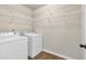 Bright laundry room with washer, dryer, and white wire shelving for efficient storage at 845 Nevis Way, Mcdonough, GA 30253