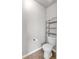 Small powder room including a toilet, tile floor, and dark storage shelving at 845 Nevis Way, Mcdonough, GA 30253