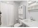 Bathroom with white cabinets, updated sink, and shower with curtain at 935 Old Loganville Rd, Loganville, GA 30052
