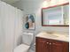 Cozy bathroom features vanity, toilet, shower with curtain, and modern art at 935 Old Loganville Rd, Loganville, GA 30052