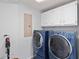 Functional laundry room with cabinets, two new front load washing machines, and shelving at 935 Old Loganville Rd, Loganville, GA 30052
