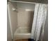 A neutral-toned bathroom features a bathtub and shower with decorative shower curtain at 1425 Parkmont Dr, Roswell, GA 30076