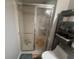 Bathroom featuring a glass enclosed shower, toilet, and open shelving unit at 1425 Parkmont Dr, Roswell, GA 30076