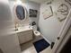 Powder room with modern oval mirror and decorative wall art at 1425 Parkmont Dr, Roswell, GA 30076