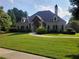Well-manicured lawn leads to a charming single-Gathering home with welcoming curb appeal and elegant stonework at 1771 Silvergrass Ln, Grayson, GA 30017