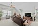 Bright, open living room with vaulted ceilings, fan, and comfortable brown leather reclining sofa at 1771 Silvergrass Ln, Grayson, GA 30017