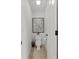 Compact powder room with tiled floor and decorative art, providing a convenient and stylish space at 1771 Silvergrass Ln, Grayson, GA 30017