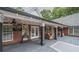 Covered brick back porch with string lights, a ceiling fan, and dark wood floors at 180 Mountain Path, Rockmart, GA 30153