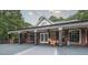 Inviting back porch with brick facade, ceiling fans, string lights and outdoor furniture at 180 Mountain Path, Rockmart, GA 30153