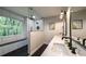 Modern bathroom with double sink vanity, open shower with black fixtures and a large picture window at 180 Mountain Path, Rockmart, GA 30153