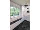 Modern bathroom features a black river stone floor, tiled walls, and a window at 180 Mountain Path, Rockmart, GA 30153