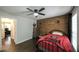 Bedroom with wood accent wall, ceiling fan, hardwood floor, and Georgia Bulldog themed bedspread at 180 Mountain Path, Rockmart, GA 30153
