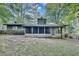 Backyard showcasing an enclosed sunroom, a patio, and a lush, green backyard at 235 Trailmore Ct, Roswell, GA 30076