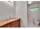 Bathroom with a marble countertop, decorative vanity, and a toilet with a window view at 235 Trailmore Ct, Roswell, GA 30076