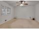 Spacious bedroom with large window, ceiling fan, and wall-to-wall carpeting at 235 Trailmore Ct, Roswell, GA 30076