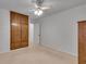 Bedroom with a large closet, ceiling fan, and neutral carpet for a comfortable space at 235 Trailmore Ct, Roswell, GA 30076