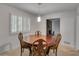 Traditional dining room with round wood table, wood chairs, and bright natural light from shuttered window at 235 Trailmore Ct, Roswell, GA 30076