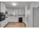 Bright kitchen featuring white cabinets, black appliances, light countertops, and tile backsplash at 235 Trailmore Ct, Roswell, GA 30076