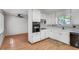 Sun filled kitchen with eat-in area, white cabinets, black appliances and wood-look floor at 235 Trailmore Ct, Roswell, GA 30076