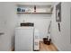 Functional laundry room with washer, shelving, and necessary supplies at 235 Trailmore Ct, Roswell, GA 30076