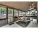 The sunroom includes a ceiling fan, a table, and many windows with views of the backyard at 235 Trailmore Ct, Roswell, GA 30076