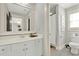 Bright bathroom with a white vanity, a large mirror and a view of the shower at 201 Beacon Cv, Canton, GA 30114