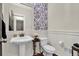 Charming powder room with pedestal sink, decorative wallpaper, and elegant fixtures at 201 Beacon Cv, Canton, GA 30114
