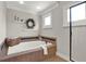 Bathroom with large soaking tub, decorative tile, and natural light from the window at 201 Beacon Cv, Canton, GA 30114