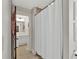 Hallway view into a bathroom with a shower with a white curtain and tiled floor at 201 Beacon Cv, Canton, GA 30114