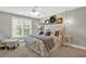 Comfortable bedroom featuring a large window, ceiling fan and decorative wall art at 201 Beacon Cv, Canton, GA 30114