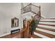 Bright foyer featuring hardwood floors, wood staircase, and decorative mirror and bench seating at 201 Beacon Cv, Canton, GA 30114
