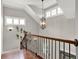 Hallway showing stairway with wood railing and decorative lighting, a window and a house plant at 201 Beacon Cv, Canton, GA 30114