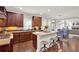 This beautiful kitchen boasts dark wood cabinets, an island with seating, and seamlessly flows into the dining and living areas at 201 Beacon Cv, Canton, GA 30114