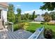 Landscaped backyard with a deck, seating, and a white barn in the background on a sunny day at 206 Savanna Estates Ct, Canton, GA 30115