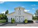 Exterior view of a well-maintained white barn with grey accents, and landscaping at 206 Savanna Estates Ct, Canton, GA 30115