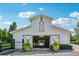 Bright barn featuring sliding doors, a white exterior, and decorative potted plants at the entrance at 206 Savanna Estates Ct, Canton, GA 30115