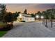 Well-lit barn at twilight with gravel driveway and mature trees, offers a perfect blend of functionality and rustic charm at 206 Savanna Estates Ct, Canton, GA 30115